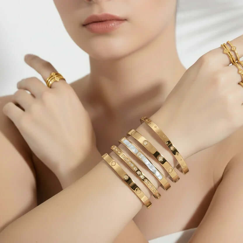 Woman wearing stacked gold bangles and rings from Ceyrah Gold Collection