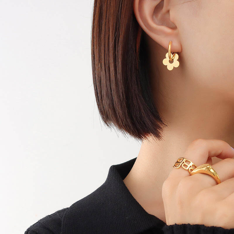 Ceyrah gold flower hoop earrings on a woman
