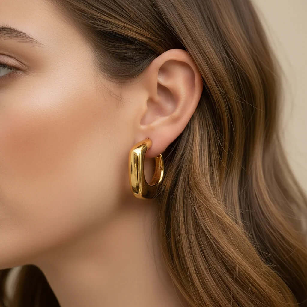 Ceyrah gold chunky hoop earring on woman with smooth brown hair
