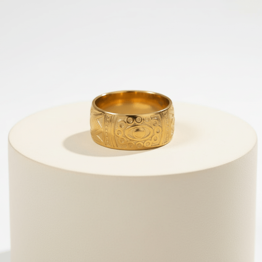 Ceyrah gold ring with engraved geometric and eye motifs on white background