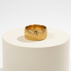 Ceyrah gold ring with engraved geometric and eye motifs on white background
