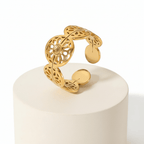 Gold Floral Leaf Cut Out Ring displayed on a pedestal showcasing its intricate floral design and open silhouette.