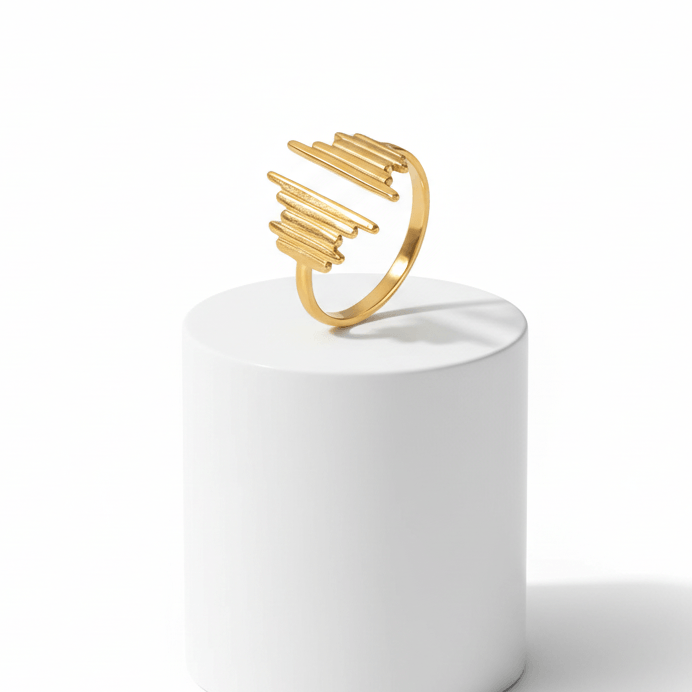 Gold Ridged Open Band Ring displayed on a white pedestal, featuring bold ridges in a contemporary design.