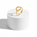 Gold Abstract Open Form Ring displayed on a white pedestal showcasing its unique, sculptural design.