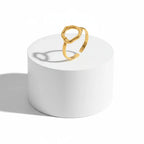 Gold Abstract Open Form Ring displayed on a white pedestal showcasing its unique, sculptural design.