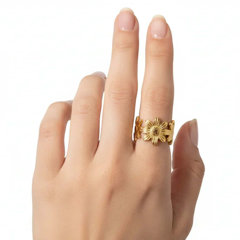 Gold Floral Linked Ring displayed on a hand with a delicate design featuring sculpted flowers.