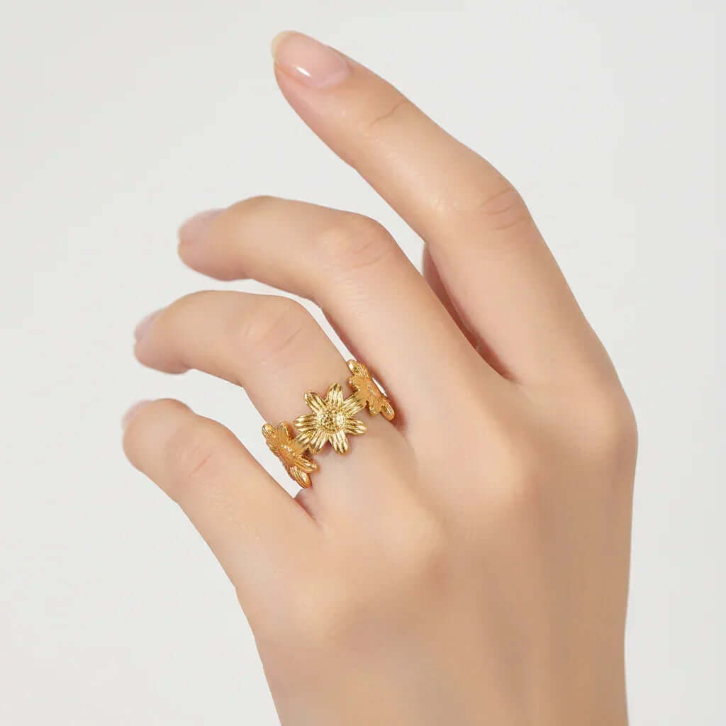 Gold Floral Linked Ring on a hand, featuring intricate sculpted flowers for a delicate and elegant look.
