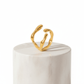 Gold Organic Sculpted Ring on a marble pedestal, showcasing its artistic and modern silhouette.