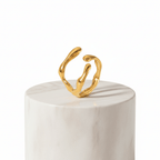 Gold Organic Sculpted Ring on a marble pedestal, showcasing its artistic and modern silhouette.