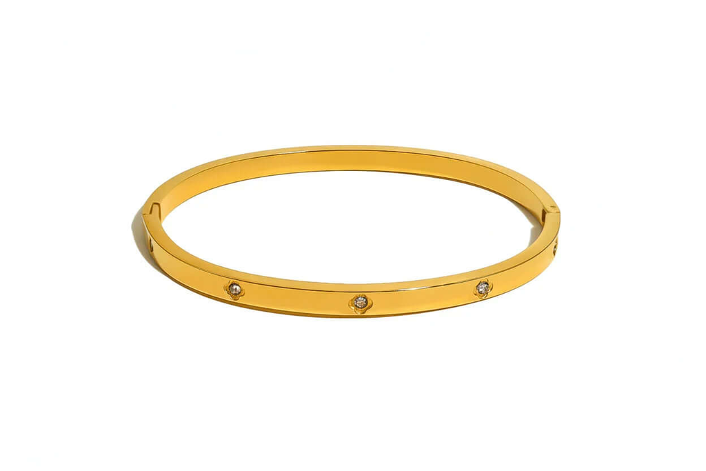 Ceyrah gold bangle bracelet with embedded clear gemstones on white background