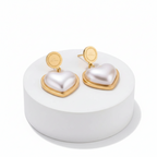 Ceyrah gold and pearl heart-shaped drop earrings on white background
