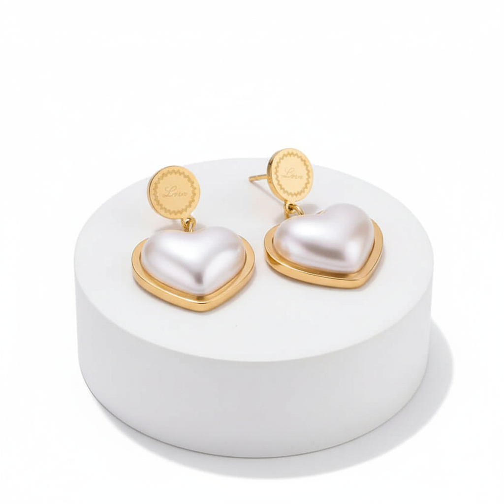 Ceyrah gold and pearl heart-shaped drop earrings on white background
