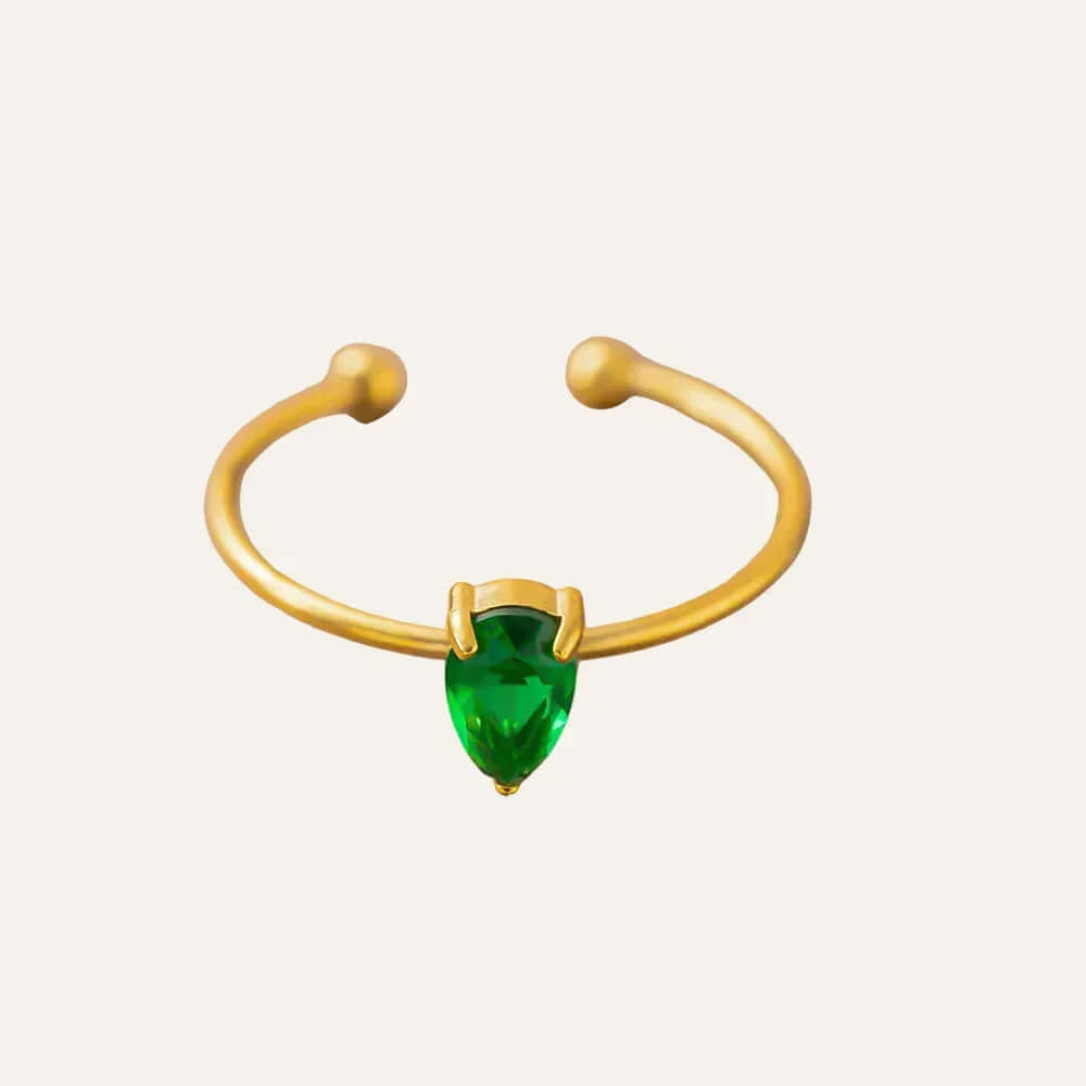 Ceyrah gold open ring with teardrop green gemstone on light background