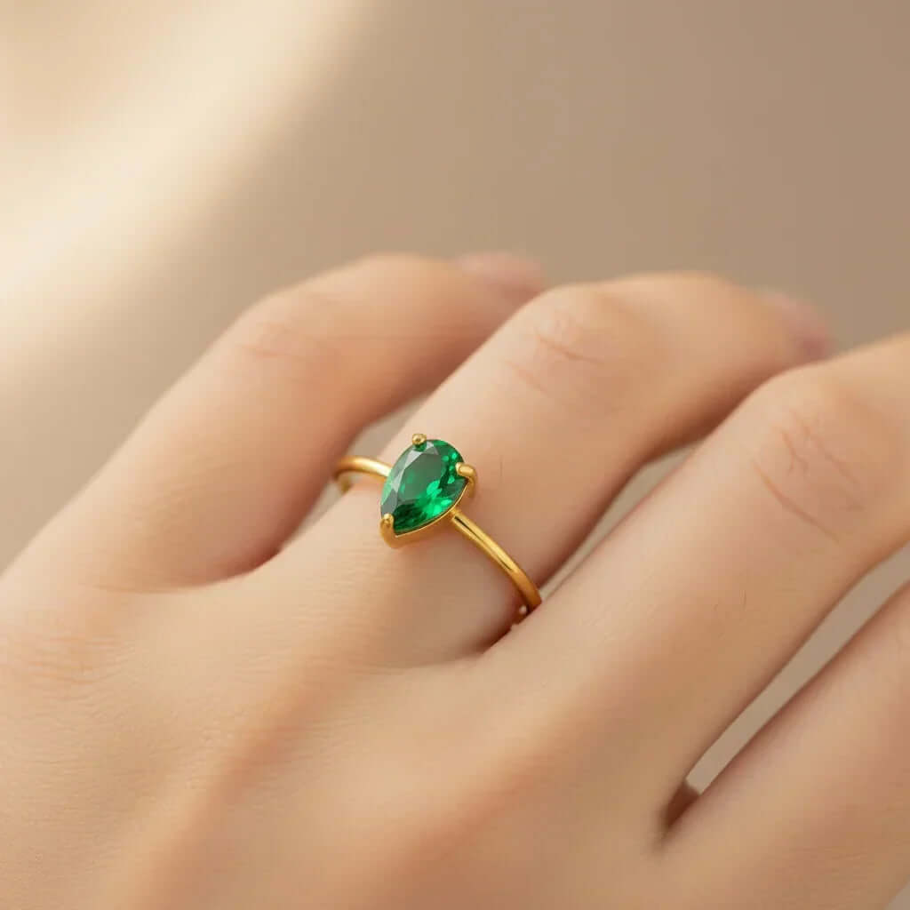 Gold ring with pear-shaped green gemstone on hand, Ceyrah jewelry