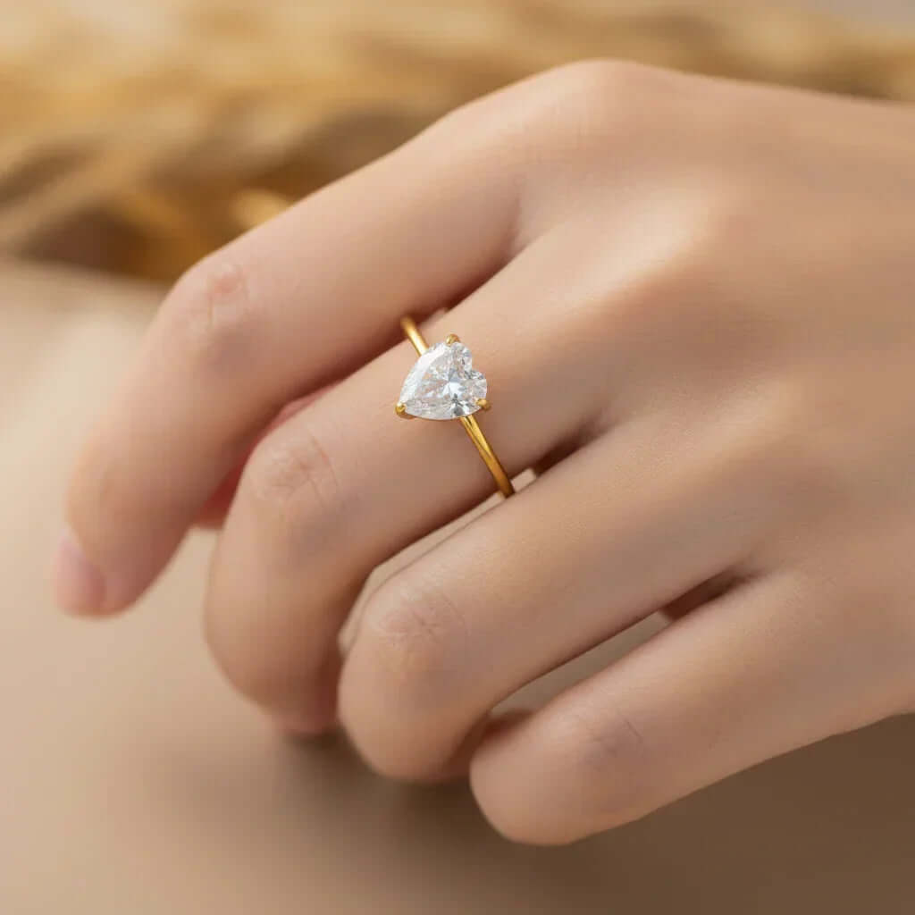Gold ring with pear-shaped gemstone on hand, Ceyrah jewelry product close-up