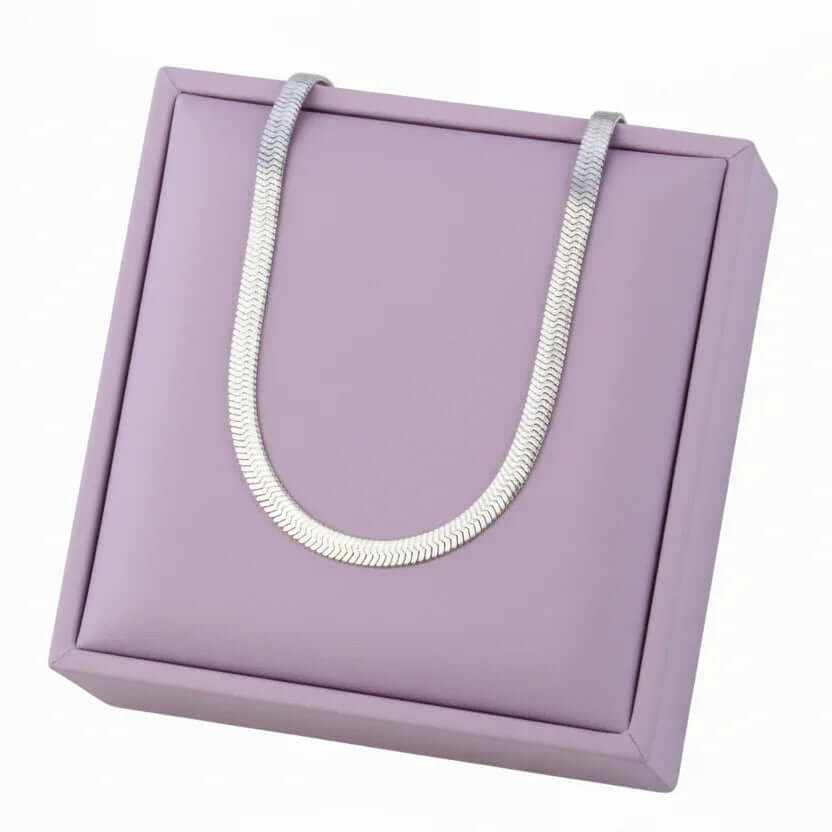 Silver herringbone chain necklace on lavender jewelry display, Ceyrah accessories