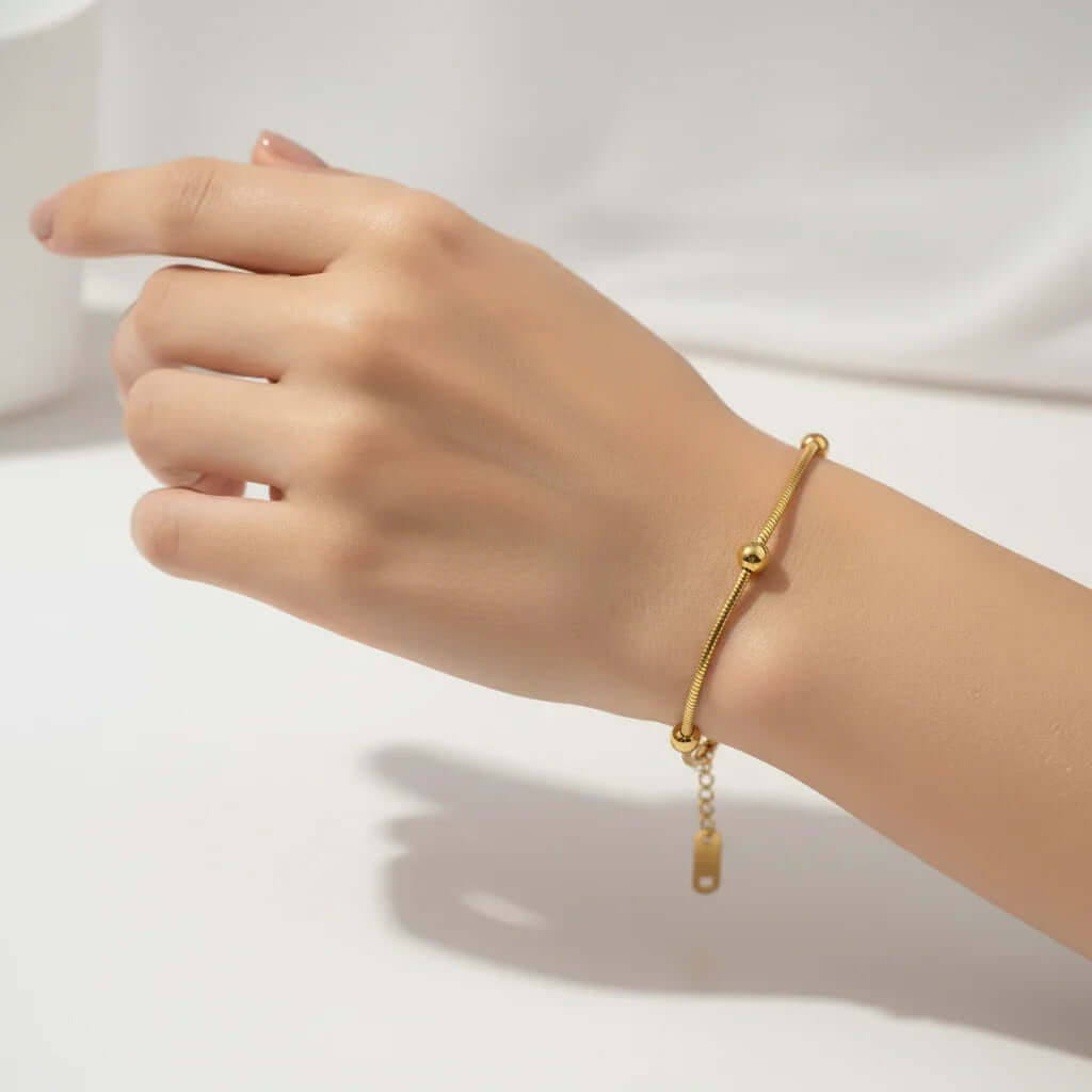 Minimalist gold bracelet on wrist, Ceyrah jewelry, elegant and simple accessory