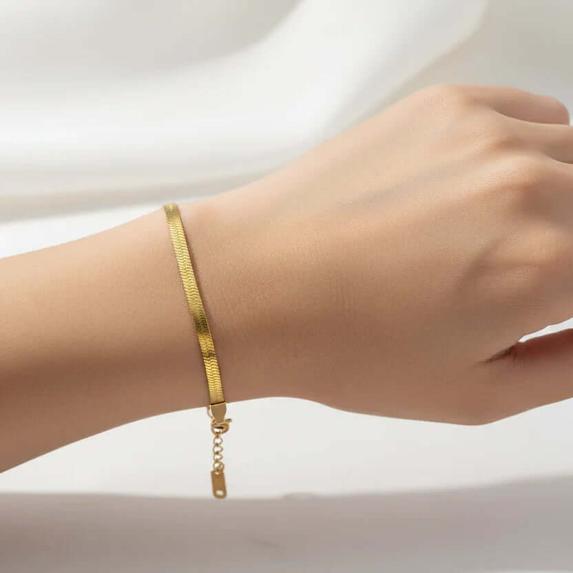 Ceyrah minimalist gold bracelet on wrist, elegant jewelry against white background