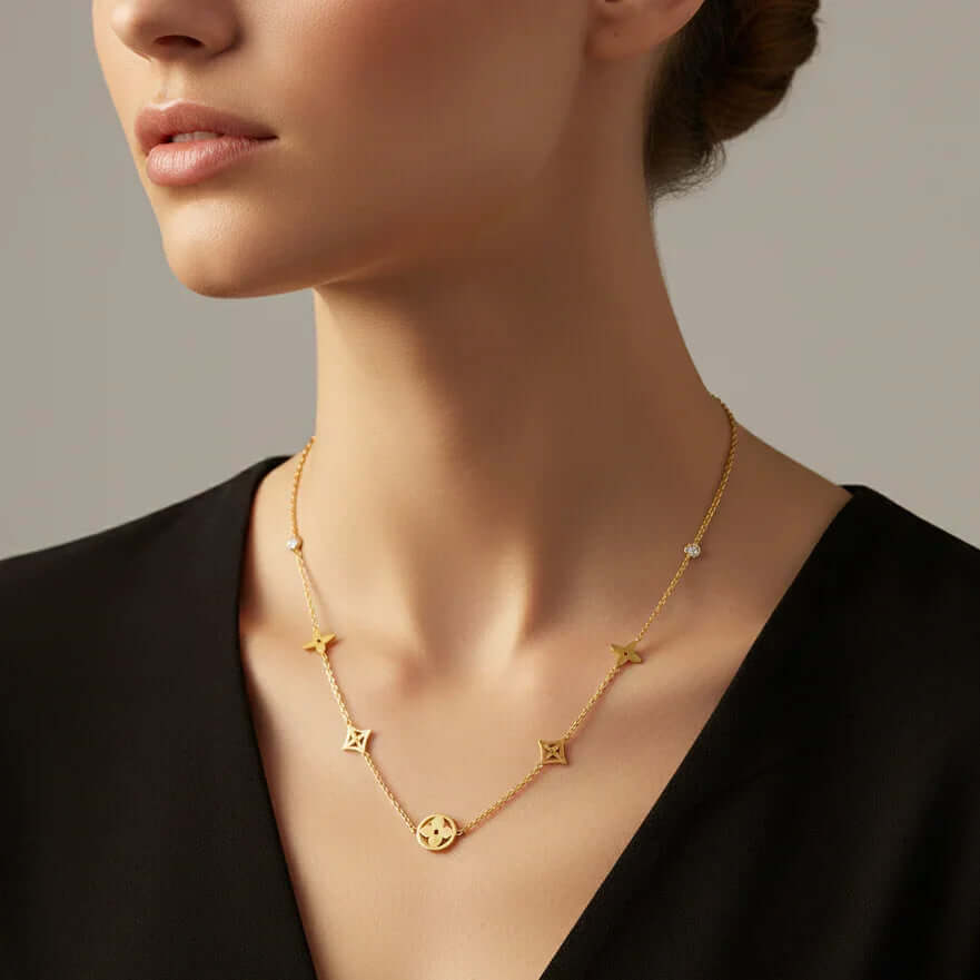 Ceyrah gold necklace with star-shaped pendants on woman in black top