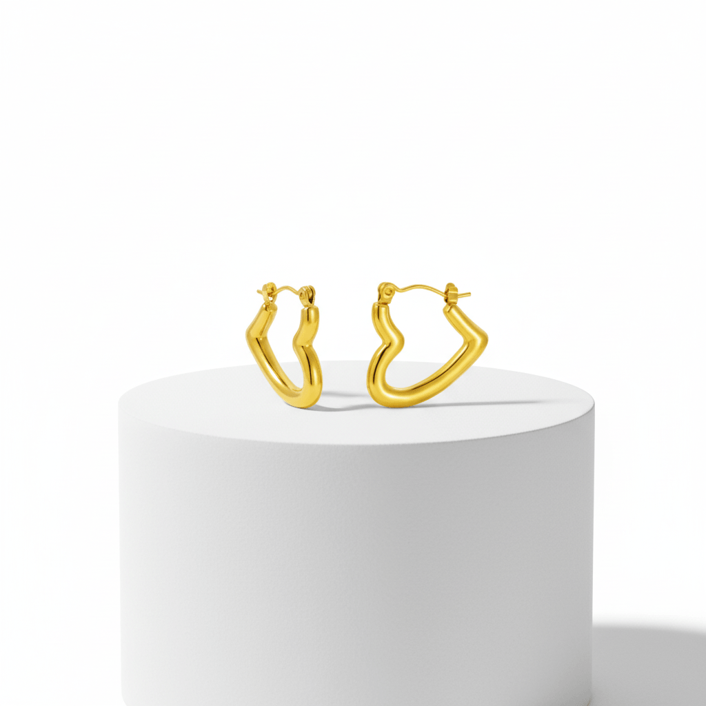 Gold hoop earrings on a white pedestal