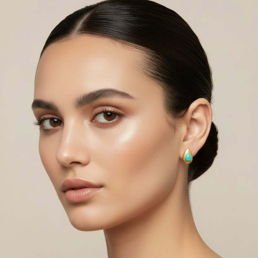 Gold Teardrop Earrings with Blue Stone worn by a model, showcasing a delicate design and elegant style.