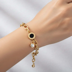 Ceyrah gold chain bracelet with black enamel charm and crystal pendant on wrist