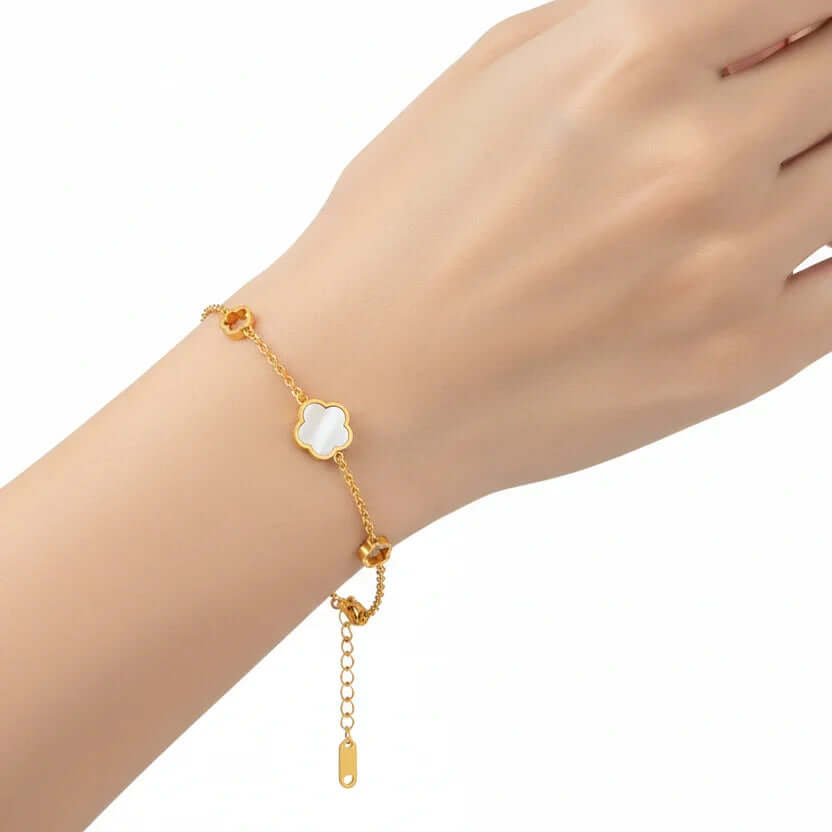 Ceyrah gold chain bracelet with white clover charms on wrist, elegant jewelry accessory
