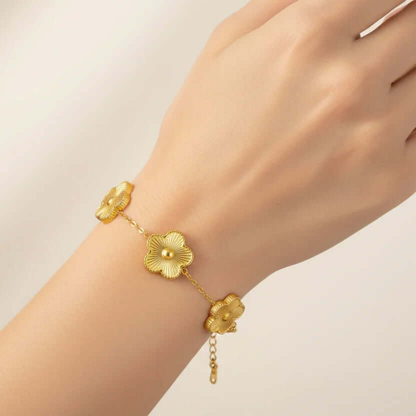 Five Leaf Clover Bracelet with gold floral charms on a wrist, showcasing an elegant design for everyday wear.