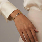 Woman wearing a gold bracelet with colorful gemstones, Ceyrah fashion jewelry