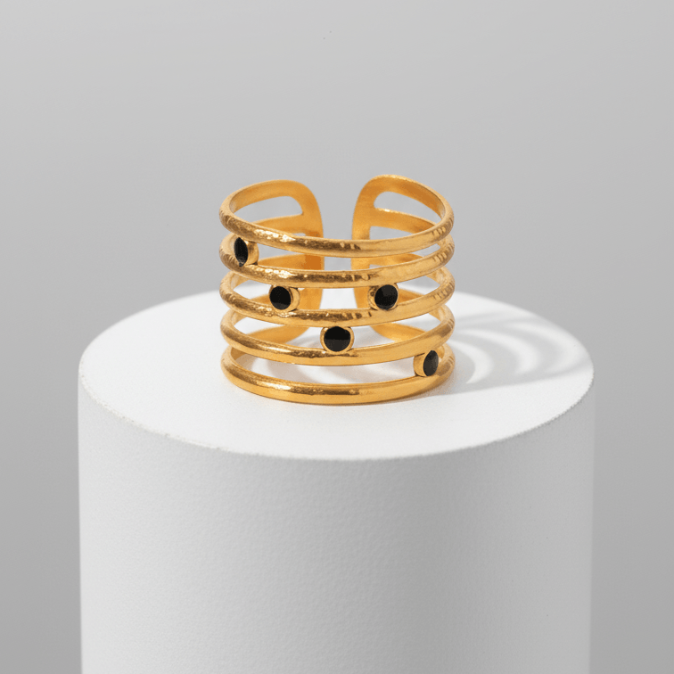 Astra Five‑Band Black Stone Adjustable Ring on a white pedestal against a gray background