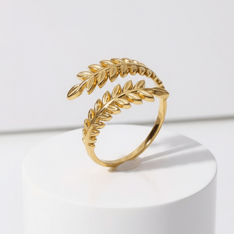 Aurelia Leaf Adjustable Gold Ring on a white pedestal with a white background