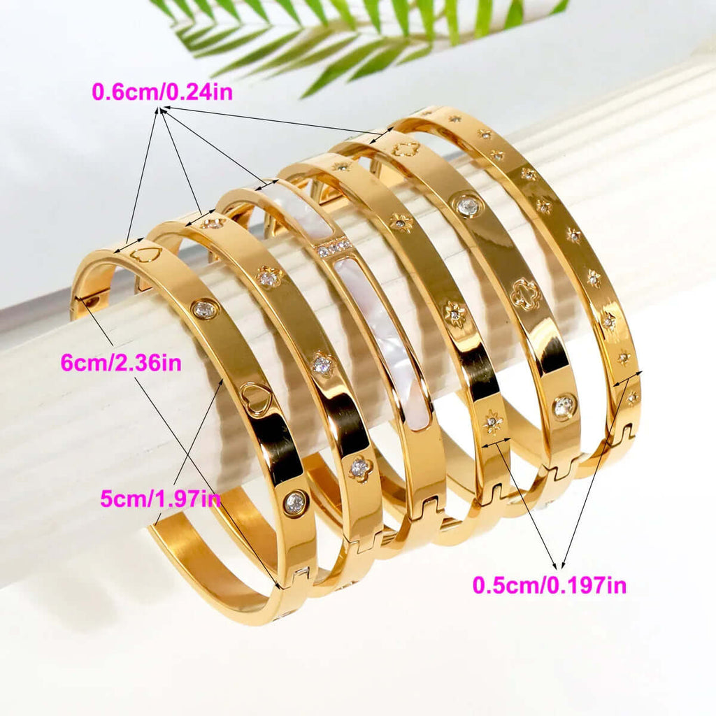 Ceyrah gold Big Clover Crystal Bangle Bracelet and heart engraved bangle bracelet, size measurements shown, on display rod