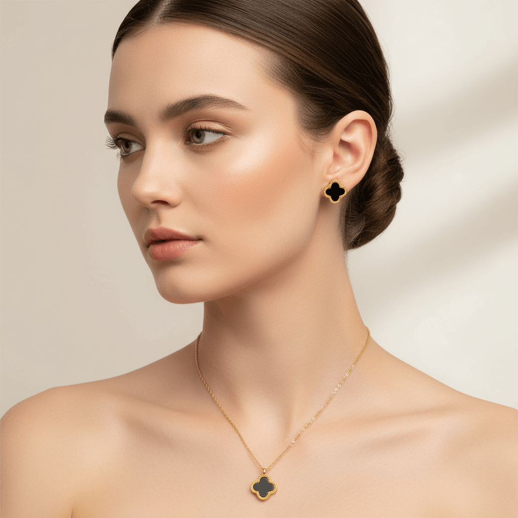 Clover Jewellery Gift Set - Gold necklace and earrings with clover-shaped pendants on a beige background