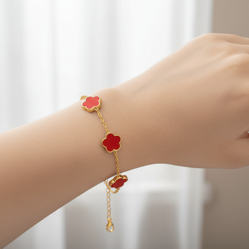 Gold Five Clover Bracelet with red floral motifs on a gold-tone chain worn on a wrist.