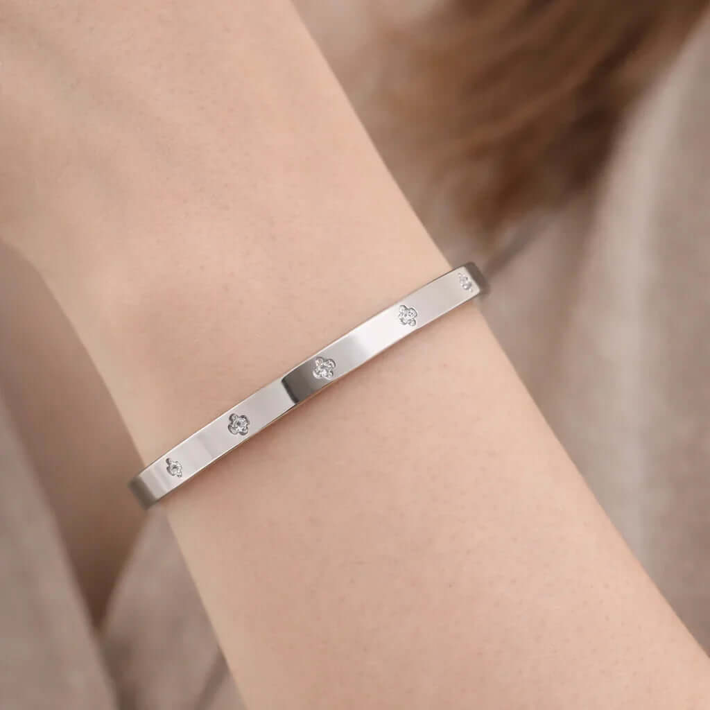Ceyrah silver bangle bracelet with floral engravings on wrist, minimal jewelry style