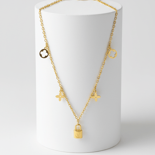Clover Charm Necklace with Lock Pendant on a white cylindrical stand against a light gray background