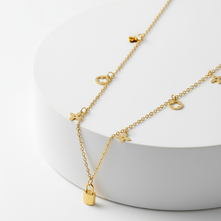 Clover Charm Necklace with Lock Pendant on a white stand with a white background