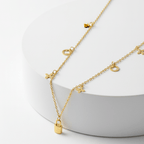 Clover Charm Necklace with Lock Pendant on a white stand with a white background