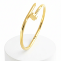 Clover Nail Bangle Bracelet on a white cylindrical stand with a white background