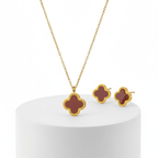 Gold necklace with red pendant and matching earrings on a white background