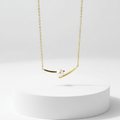 Cross Pearl Gold Necklace on white pedestal