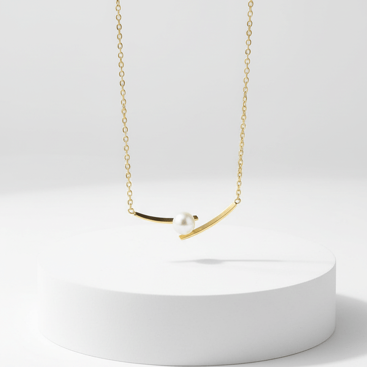 Cross Pearl Gold Necklace on white pedestal