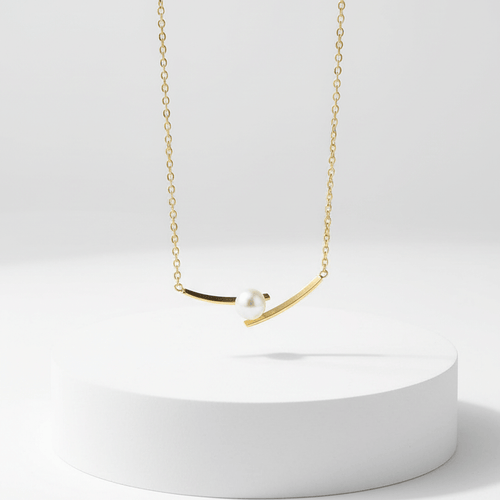 Cross Pearl Gold Necklace on white pedestal