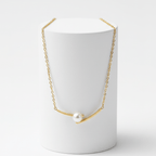 Cross Pearl Gold Necklace on white pedestal