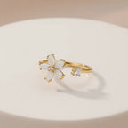 Dainty Bloom Open Gold Adjustable Ring on a beige background