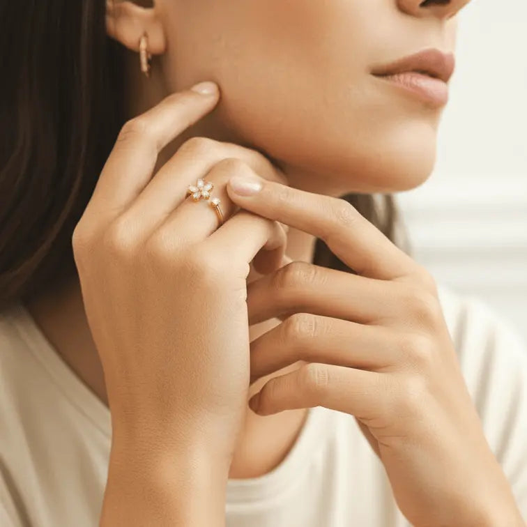 Close-up of a woman's hand wearing a Dainty Bloom Open Gold Adjustable Ring, with a blurred background.