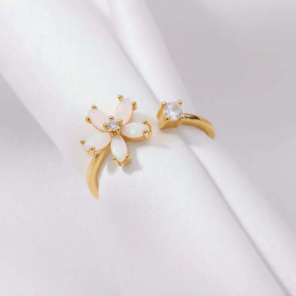Dainty Bloom Open Gold Adjustable Ring with floral design and clear stones on beige fabric
