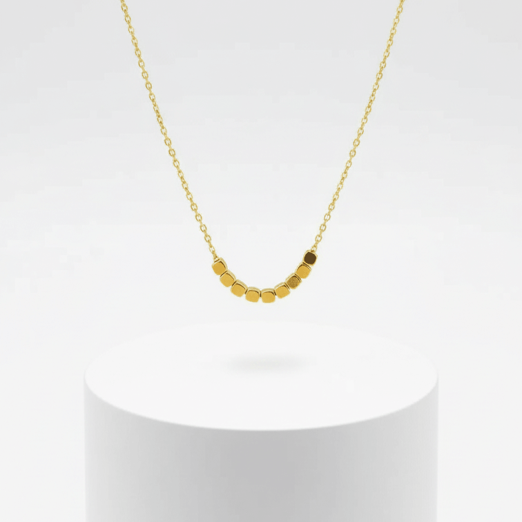 Dainty Square Gold Necklace on photoshoot over white pedestal 
