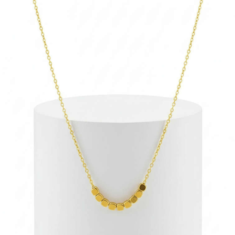 Dainty Square Gold Necklace on white background front of pedestal