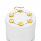 Five Leaf Clover Bracelet with golden clover charms on a minimalist display pedestal.
